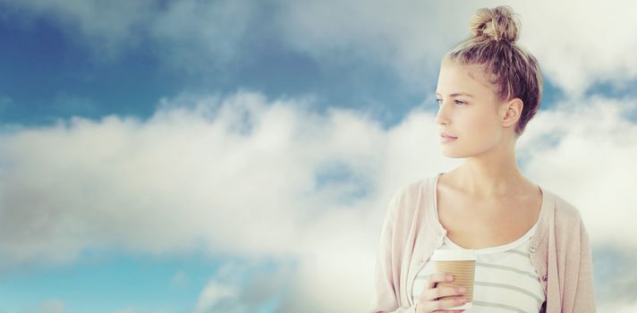Woman holding coffee cup  against blue sky with clouds