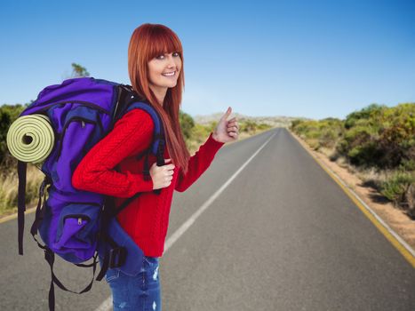 Smiling hipster woman with a travel bag against picture of a street