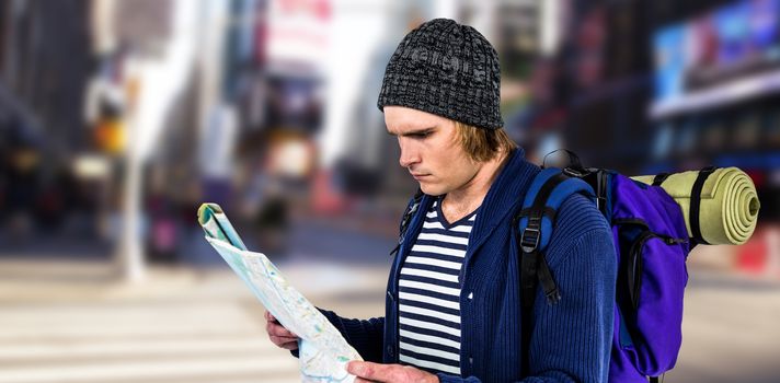 Backpacker looking a map against blurry new york street