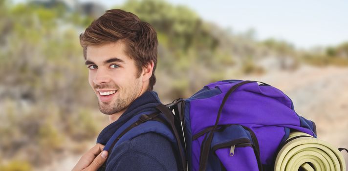 Side view of happy man with backpack against mountain trail
