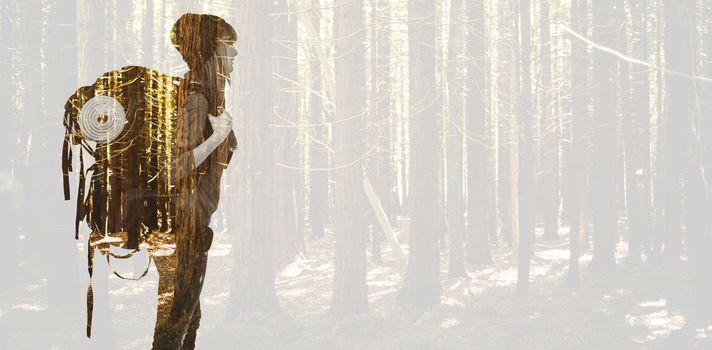 Side view of a hipster woman with a travel bag against trees in a woods