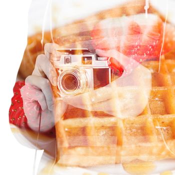 Mid section of man with camera against waffles and half cut strawberry together in a white plate