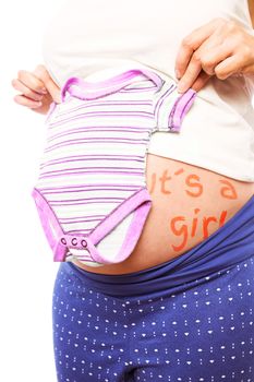 Pregnant woman holding pink pyjamas over her belly