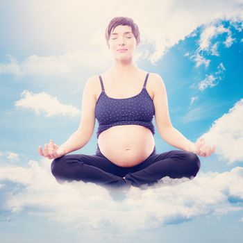 Pregnent woman sitting on mat in lotus pose over white background against blue sky
