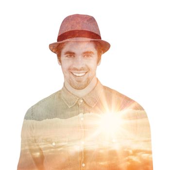 Portrait of happy hipster wearing hat against sunrise over mountains