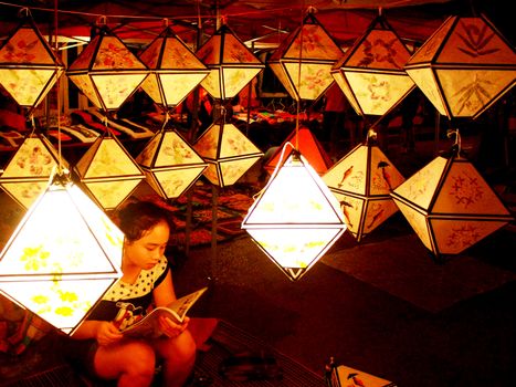 Girl read a book in the light of paper lamp