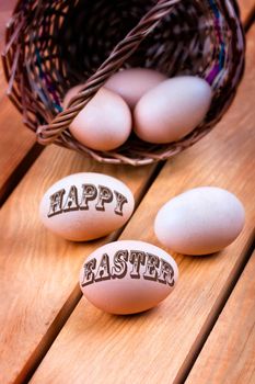 Happy easter - eggs in a basket on a wooden background
