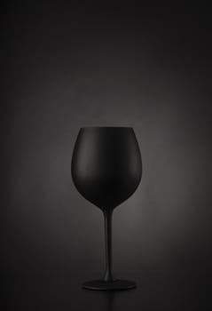 Black glass of wine on black background