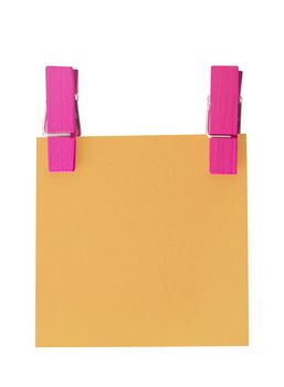 Orange paper note held by two pegs on white background