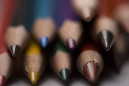Group of colored pencils with shallow depth of field on grey background. 