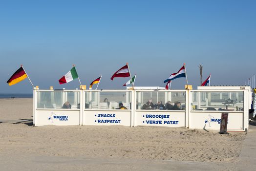 HOEK VAN HOLLAND,NETHERLANDS - FEBRUARI 17: Unidentified people sit and relax in beach tent  on Februari 17 2016 in Hoek van Holland, this beach is the beach with the view on inccoming ships to Rotterdam harbour.