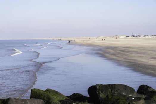 HOEK VAN HOLLAND,NETHERLANDS - FEBRUARI 17: Unidentified people walking on the beach near the sea on Februari 17 2016 in Hoek van Holland, this beach is the beach with the view on inccoming ships to Rotterdam harbour.