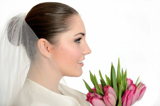 Young bride with white veil. side-face photo of female model with tulips.