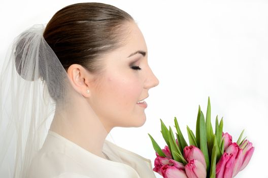 Young bride with white veil. side-face photo of female model with tulips.