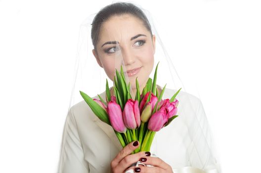 Female model, face covered with veil. Bride holds tulips bouquet. Portrait in studio with white background.
