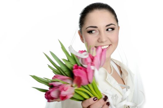 Bride with white veil and white dress throwing tulips bouquet. Female model in studio with white background.