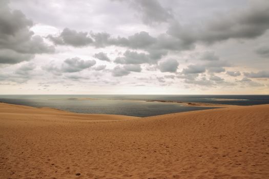 Dune of Pilat, view over the ocean and cloudy sky. Dune du Pilat, the tallest sand dune in Europe, located in the Arcachon Bay area, France.