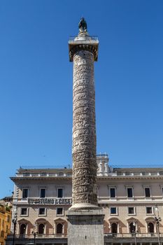 Close up detailed view of Column of Marcus Aurelius with historical hieroglyphics at Piazza Colonna, on bright blue sky background.