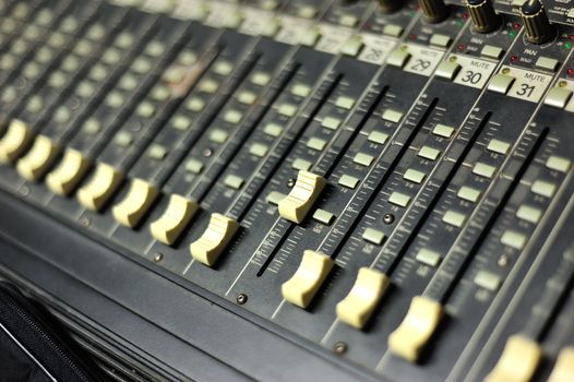 An Audio mixing table in soft light .