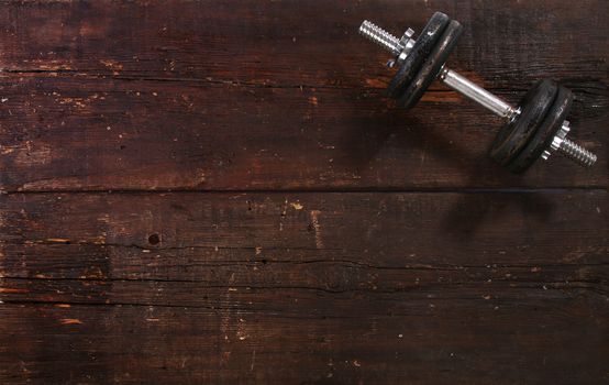 Dumbbell exercise weight on a rusty wooden floor