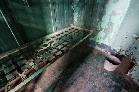 wide angle view of an old prison bed