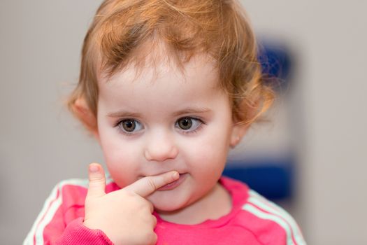 Happy cute little one year old girl indoor in white pink dress