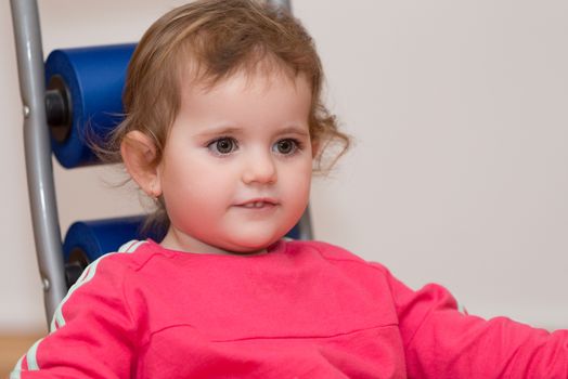 Happy cute little one year old girl indoor in white pink dress