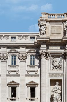 Close up detailed view of famous histroical baroque Fontana De Trevi, with the name os Trevi Fountain, on cloudy blue sky background.