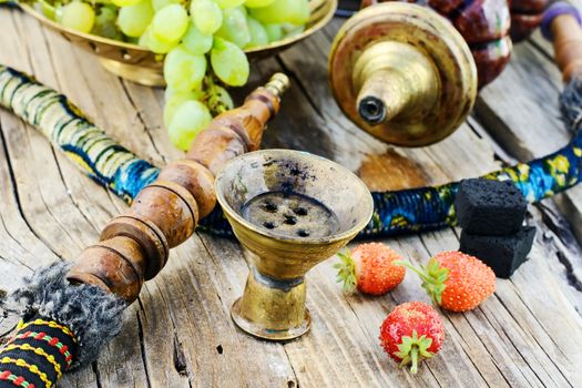 Still life with smoking hookah and grapes on wooden background