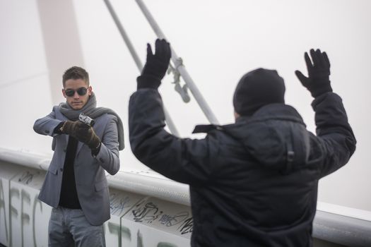 Killer drawing a bead on unrecognizable person while standing on foggy bridge