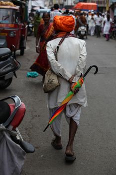 Pune, India - July 11, 2015: An old warkari walking down the road during the famous Wari festival in India.
