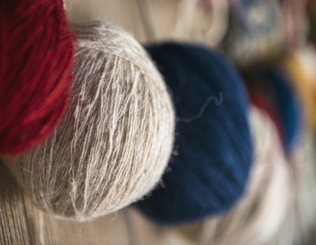 Naturally dyed balls of yarn in white, red, blue, yellow and green