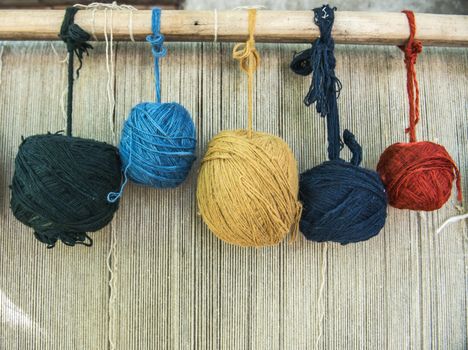 Naturally dyed balls of yarn in white, red, blue, yellow and green