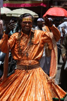 A man dressed in a traditional dancing attire during a religious festival in India.