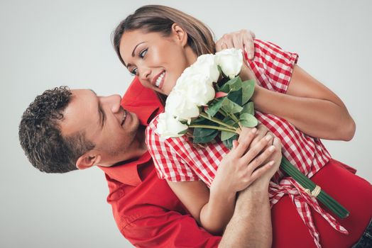 Happy loving couple holding bouquet white roses. 