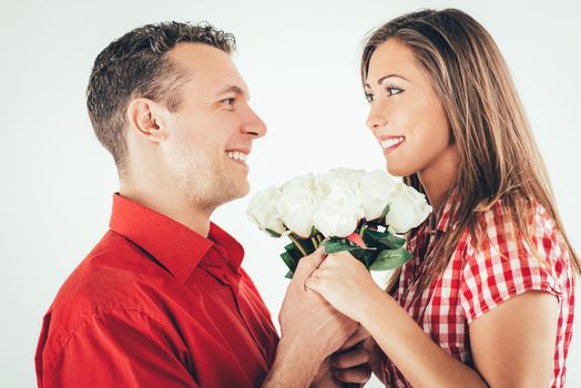 Happy loving couple holding bouquet white roses. 