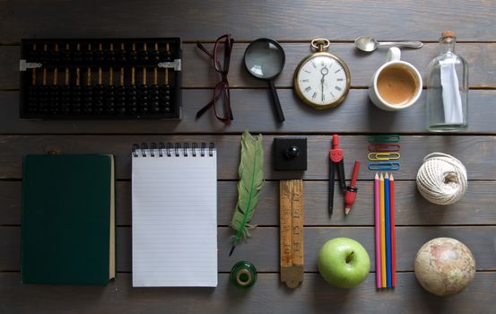 Various items, including stationery and vintage,  laid out on a wooden background