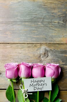Pink flowers on a wooden backdrop with a blank gift tag  and copyspace 