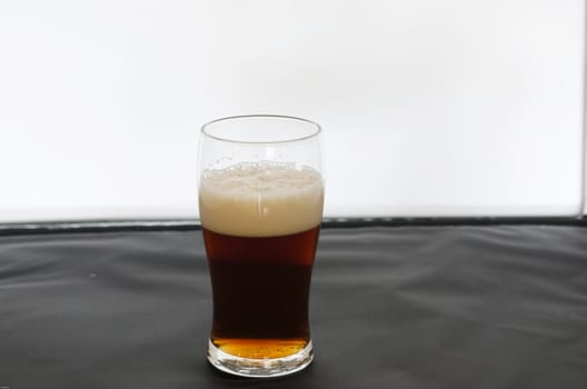 one glass of coold and dark beer ready to drink