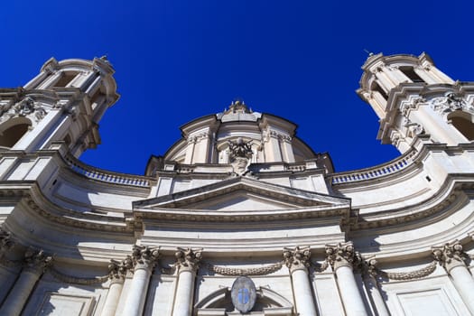 Close up detailed bottom view of the historical baroque church of Sant'Agnese at Piazza Navona, on bright blue sky background.