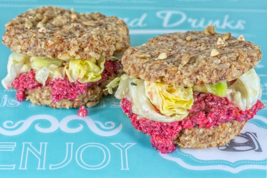 Raw burgers with beetroot and salad on a blue background