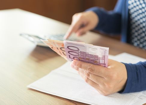 Women checking expenses monthly and banknote. select focus.
