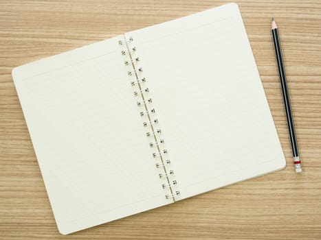 opened notebook and pencil on desk. view top
