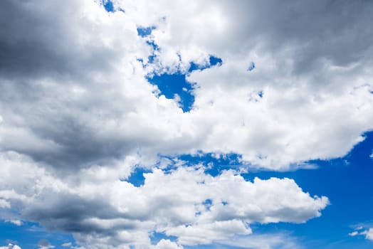 Abstract background of blue sky with white clouds and rain clouds.