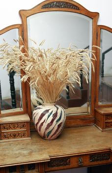 Nice bunch of dry wheat on vintage dresser with mirror