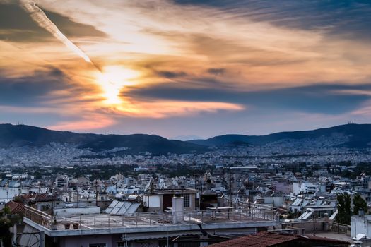 White residential houses. Mountains in the background. Colorful sunset at the cloudy sky.