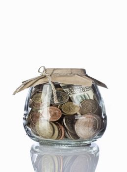 Close up view of container filled with coins on white back