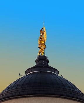 Golden statue of the patron saint on Bergamo cathedral, Italy