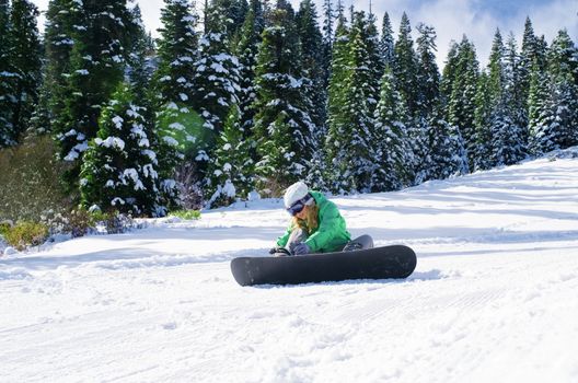 view of a young girl snowboarding in winter environment