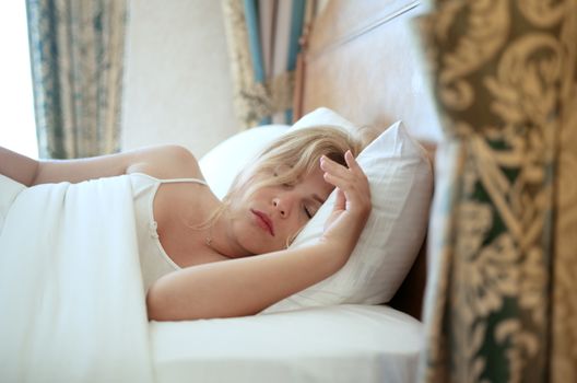 close up portrait of sleeping young woman on color back